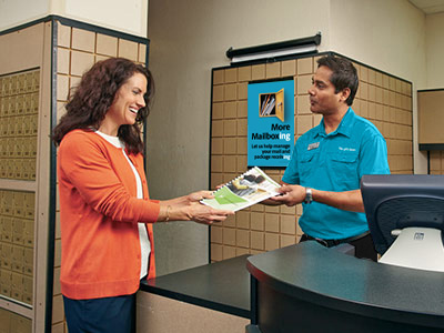 Associate showing female customer printed newsletter